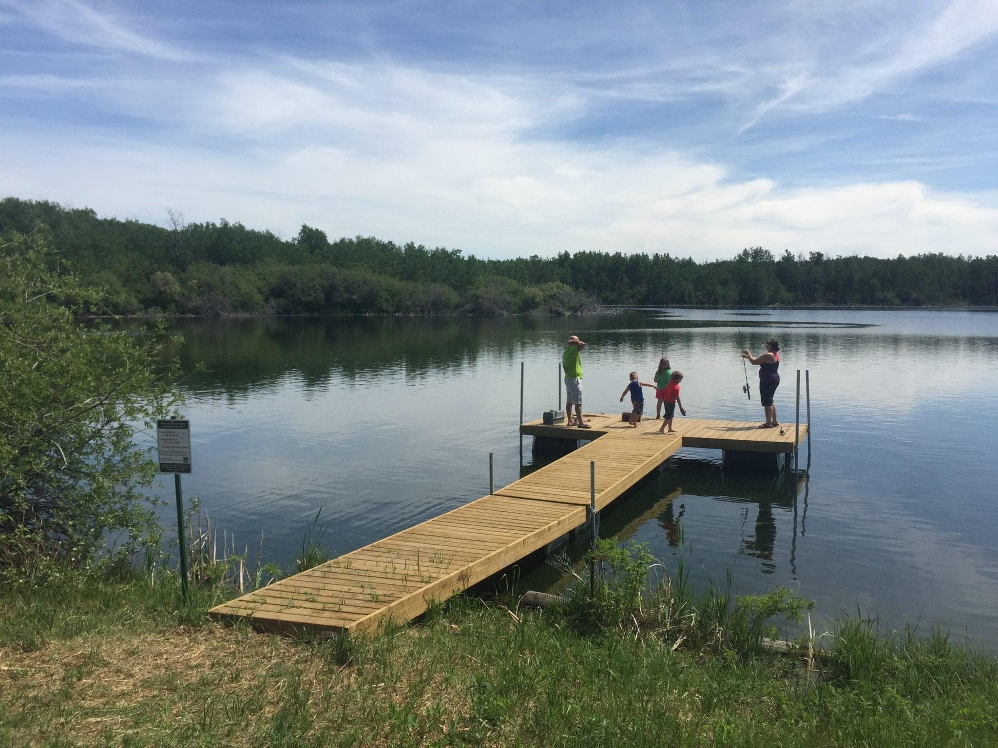 Families fishing from a dock on a lake